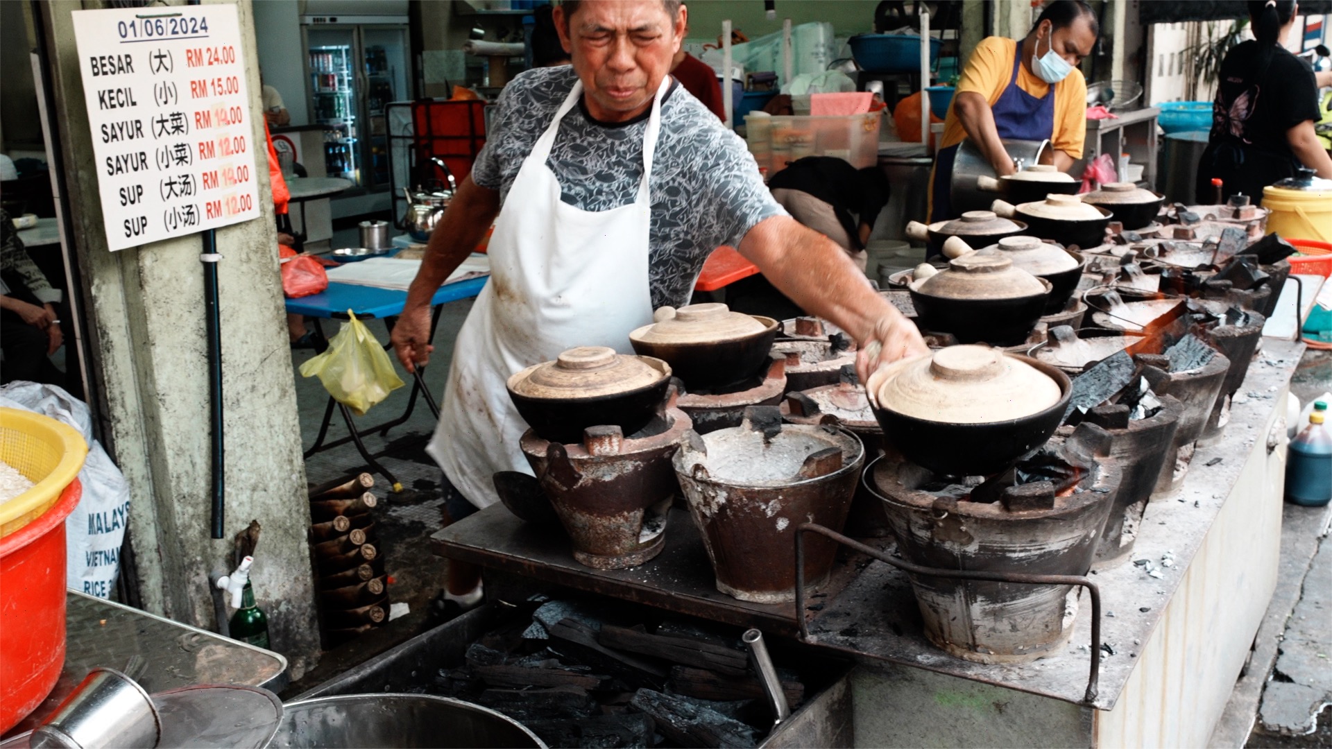 Cooking claypot rice over hot coals
